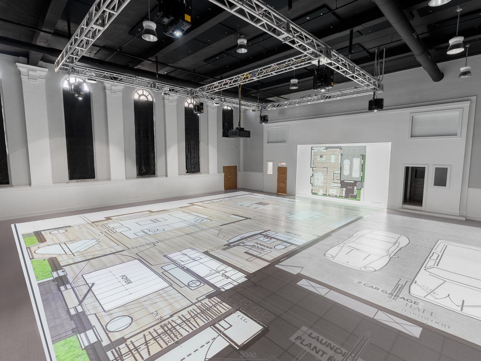 A large layout projected at full scale across the studio floor