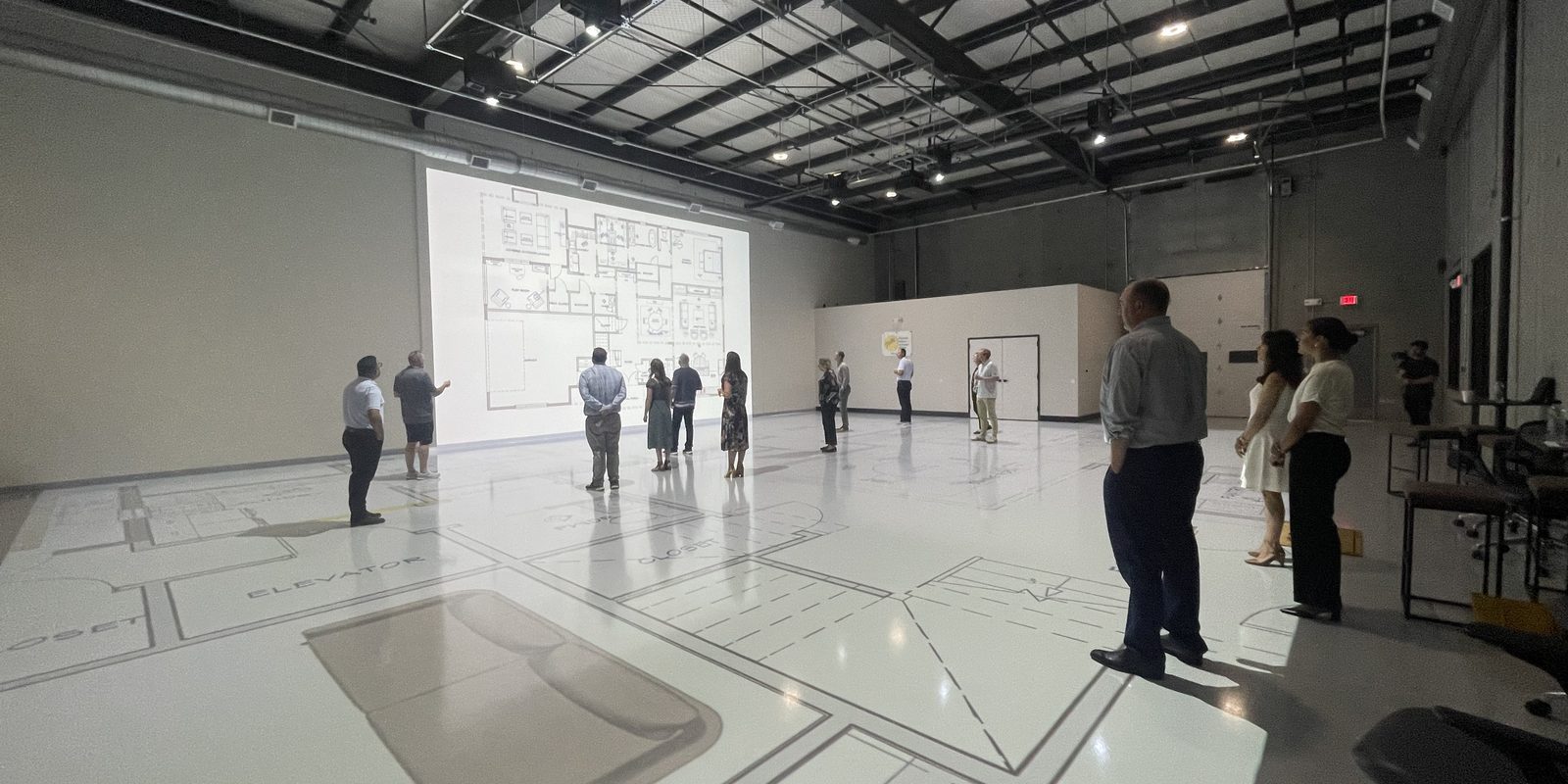 Team members walking a projected building layout